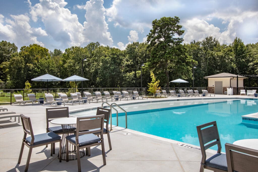Apartments in Norcross, GA, with an In-Unit Washer and Dryer - The Darnell Apartments - Swimming Pool With A Wide Sundeck, Lounge Chairs, Umbrellas, And Poolside Tables And Chairs.